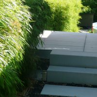 Planung und Neugestaltung eines Vorgartens in Friedberg / modern - Schotterweg mit weißen Trittplatten, bepflanzt mit Bambus.