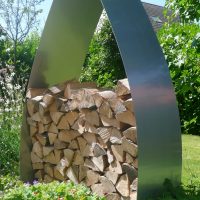 Moderne Aufbewahrung von Brennholz in Gestell aus Edelstahl