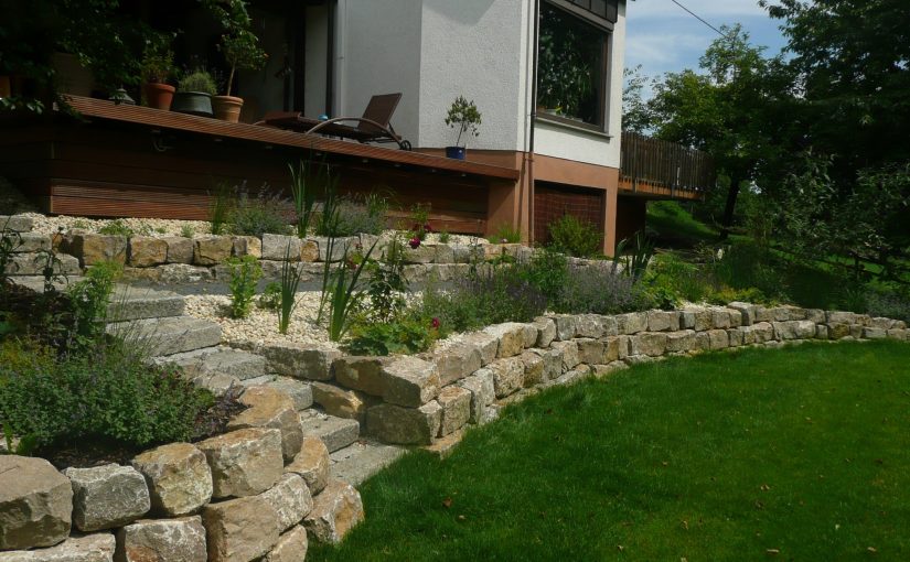 Hanggrundstück Garten Umgestaltung. Terrassiert, mit Gartenmauer und Staudenbeeten.