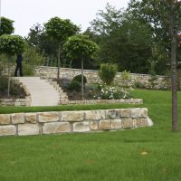 Gartendesign für den neuen Garten - Treppe im Blumenbeet, abgemauert mit Natursteinen.