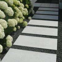 Planung und Neugestaltung eines Vorgartens in Friedberg / modern - Gartenweg mit hellen Trittplatten in dunklem Schotter, bepflanzt mit weißen Hortensien.