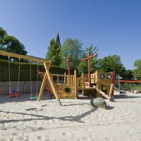 Holzschaukel und grosses Spielschiff - Aussenanlage Spielplatz Kindergarten Stadt Gelnhausen Höchst