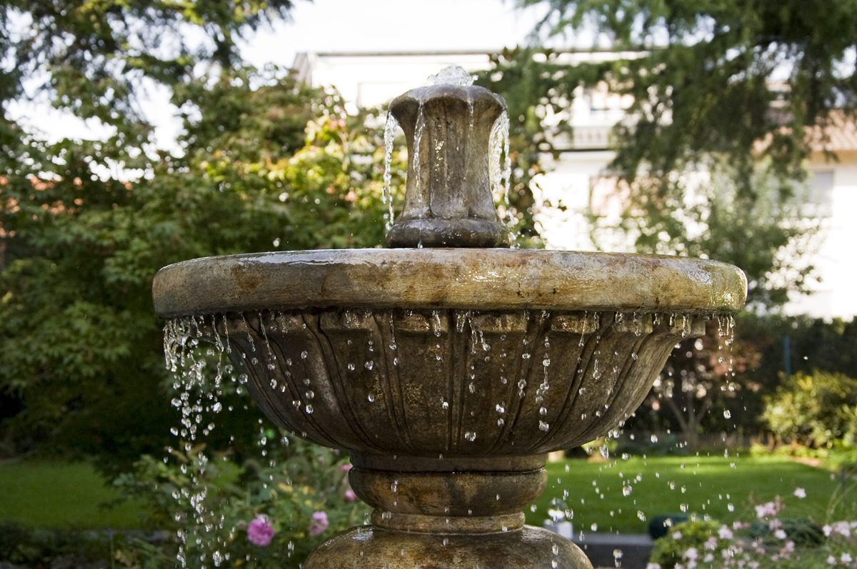 Klassischer Springbrunnen als Zentrum des neu gestalteten Gartens