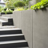 Gartenplanung eines modernen Gartens in Bad Homburg - Treppe mit Rinnit Blockstufen und Terrassiert mit Mauerplatten in Anthrazit.