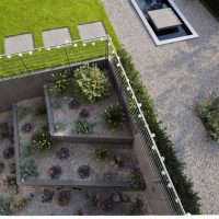 Gartenplanung eines modernen Gartens in Bad Homburg - Blick auf den versunkenen Garten, die Kiesbeete bepflanzt mit Ziergräsern, Sukkulenten und Purpurglöckchen.