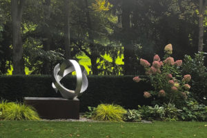 Kunst im Garten | Skulptur aus Edelstahl in Staudenbeet - neben Japan Segge, zweifarbige Funkien und Hortensien ein besonderes Motiv in dem modernen Garten.
