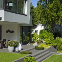 Moderner Garten, Treppe zur Terrasse mit Dekoration und Wasserspiel aus Edelstahl