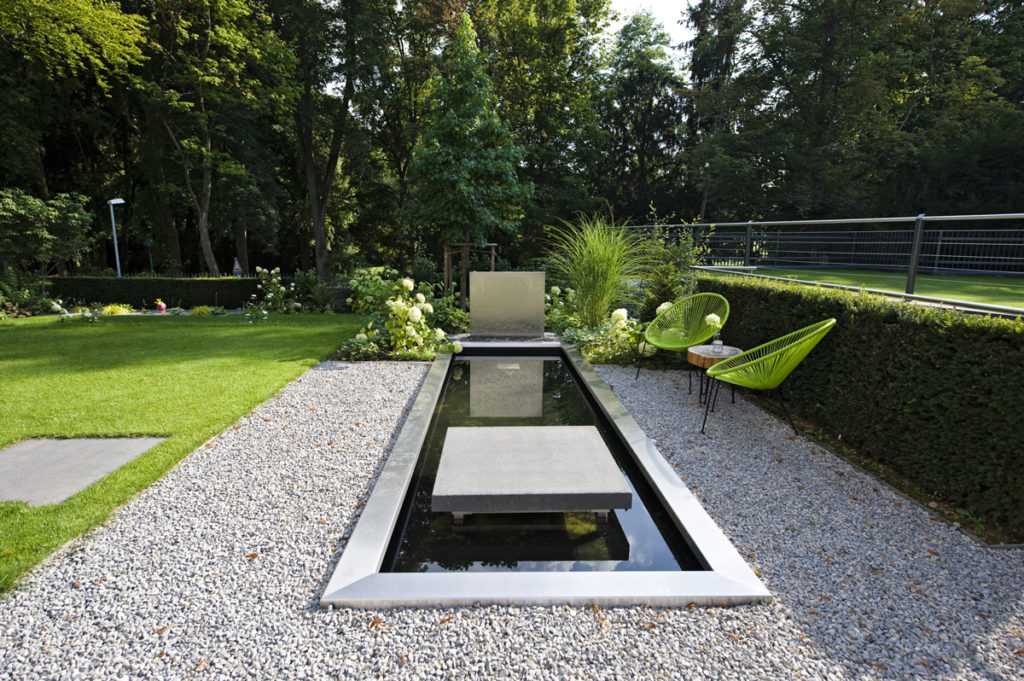Neu geplanter und gestalteter Garten in modernem Design - Wasserbecken mit Wasserfall / Wasserwand aus Edelstahl, Rinnit Trittplatte in der Rasenfläche und Kiesweg.