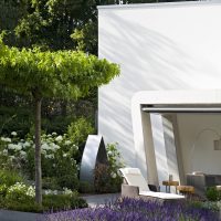 Gartenplanung und umgestaltung des Gartens mit überdachter Terrasse in modernem Design, Pflanzinseln mit Lavendel im Kiesweg, Schirmplatane mit Edelstahlkante als Umrandung.