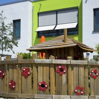 Kita Kunterbunt Langenselbold | Aussenanlage Spielhaus mit Zaun aus Holz
