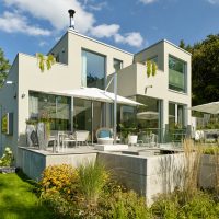 Gartenplanung | Moderner Garten | Gebäudeansicht | Terrasse mit Wasserbecken Betonoptik mit Trittstufen | Ansicht Rasenfläche und Staudenbeete